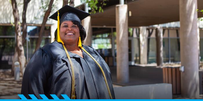 Stacie Williams poses for the camera in her graduation cap and gown.